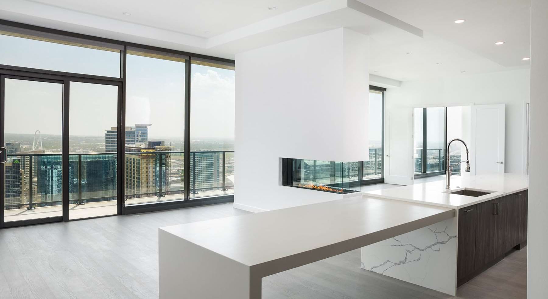an empty kitchen and living room with large windows