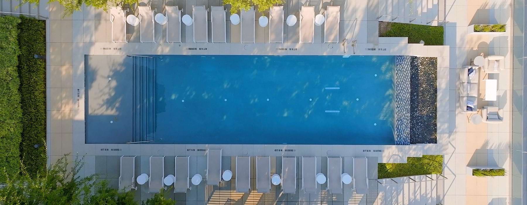 an aerial view of a swimming pool with chairs