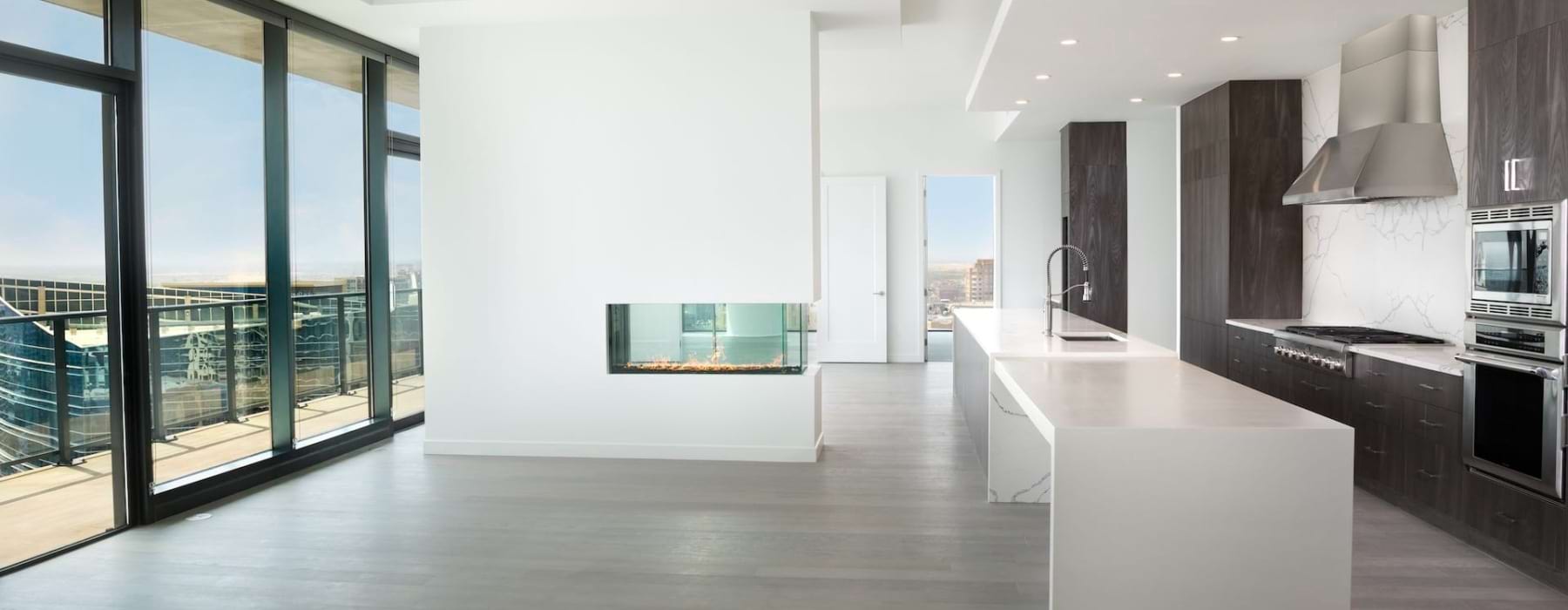 an empty kitchen and living room with large windows