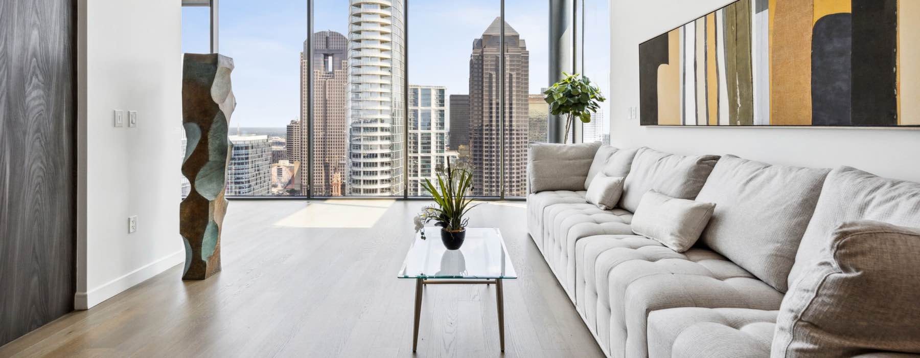 a couch and a table in a room with a window and a city