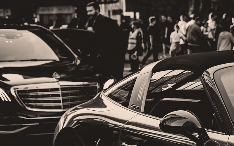 cars on a street with people in the background